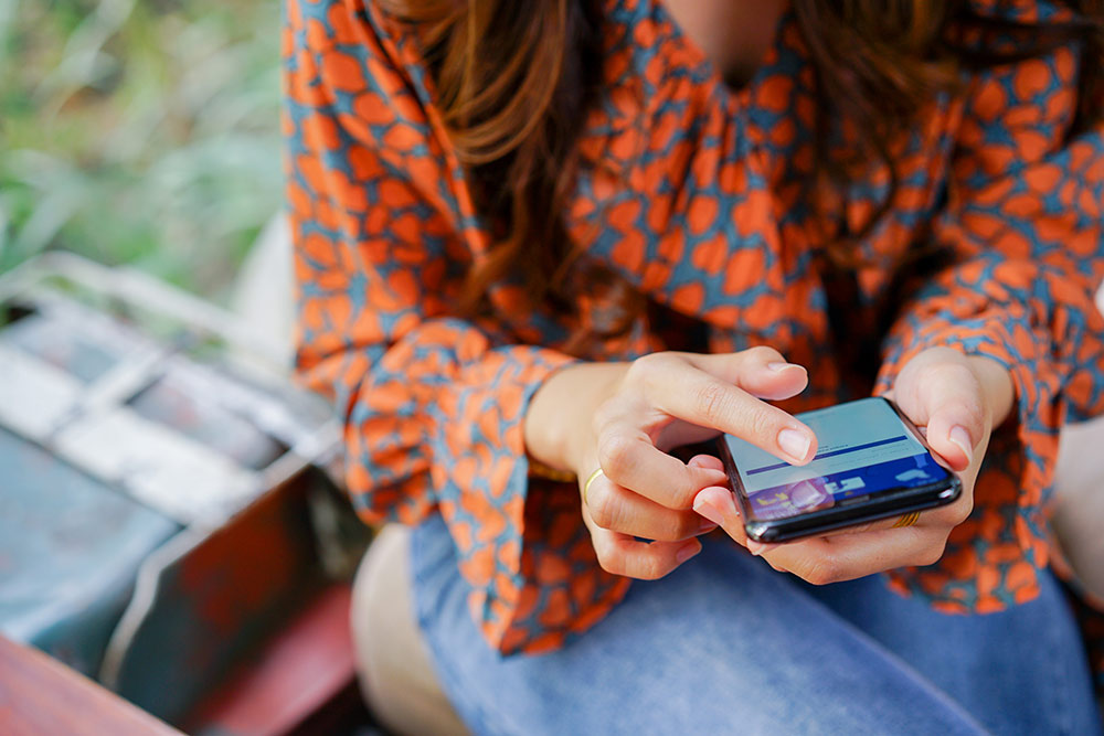 Woman looking down at smartphone on Facebook