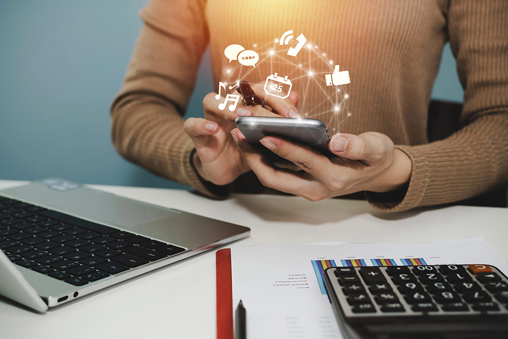 Close up of woman on smartphone looking at social media, emojis coming off of phone