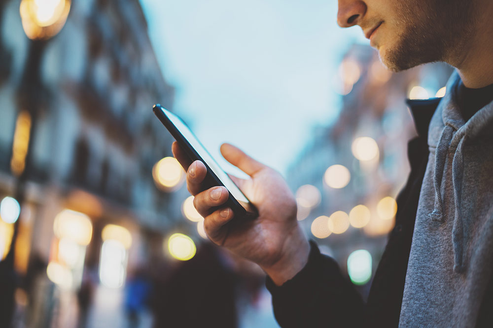 Man outside looking at smartphone