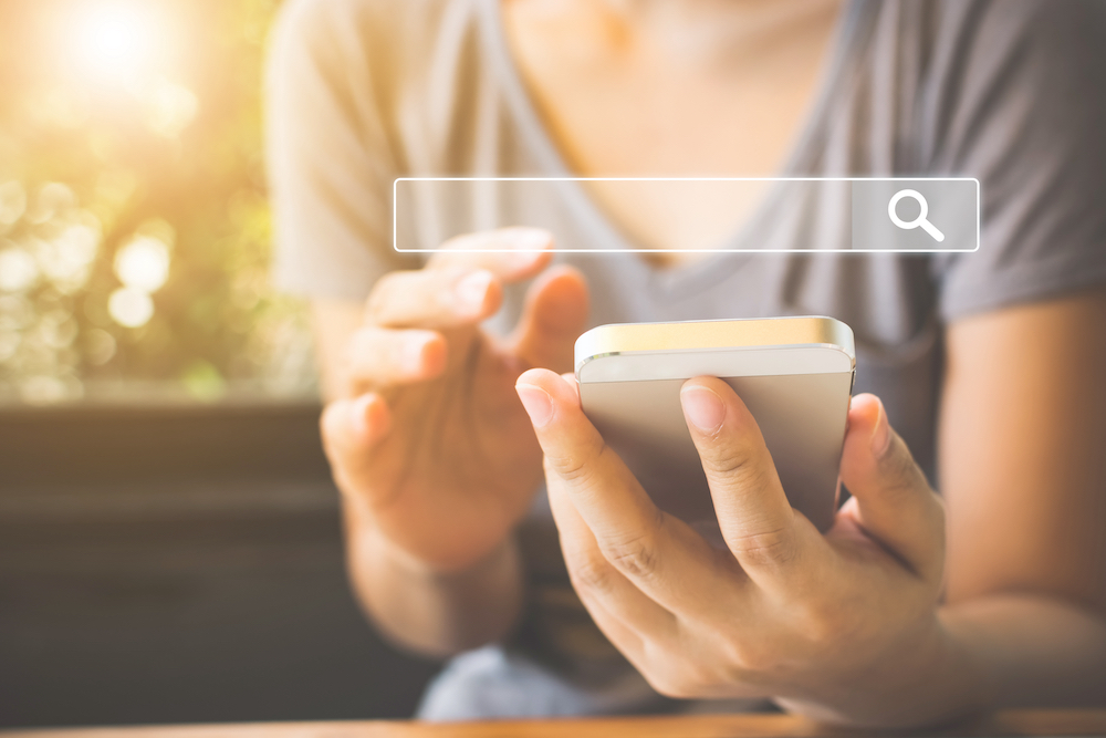 Woman uses her phone to search the web