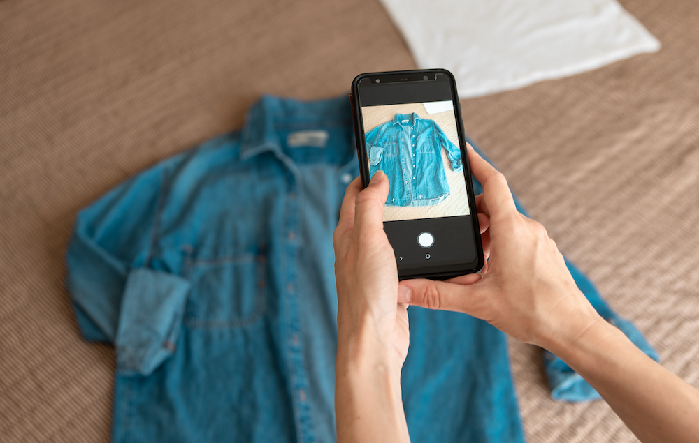 A woman taking a social media marketing photo of a denim shirt
