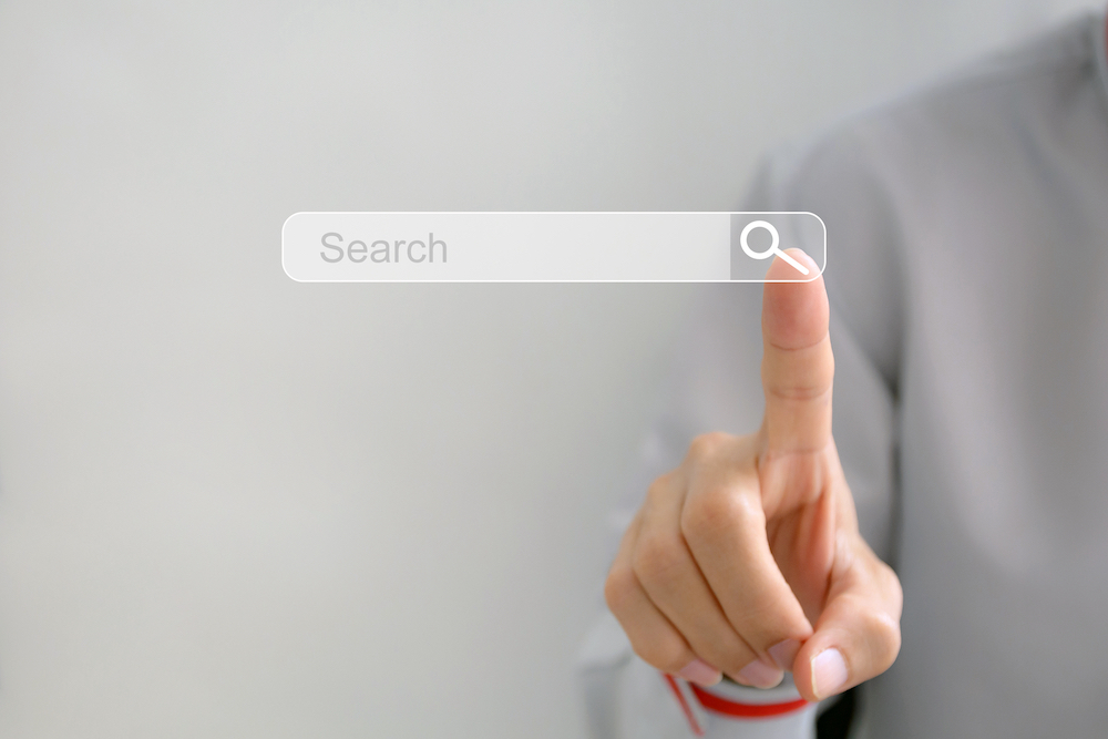 A man touches a search bar on a screen
