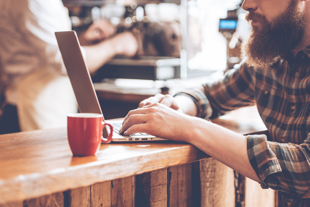 A man writing a blog in a coffee shop