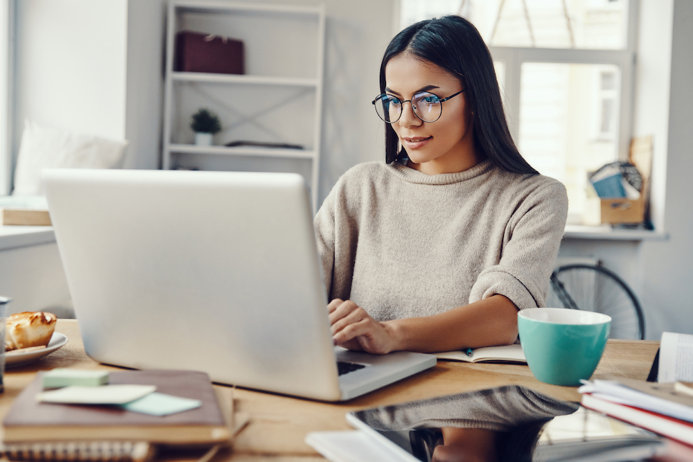 A woman typing on her computer while sitting at her desk