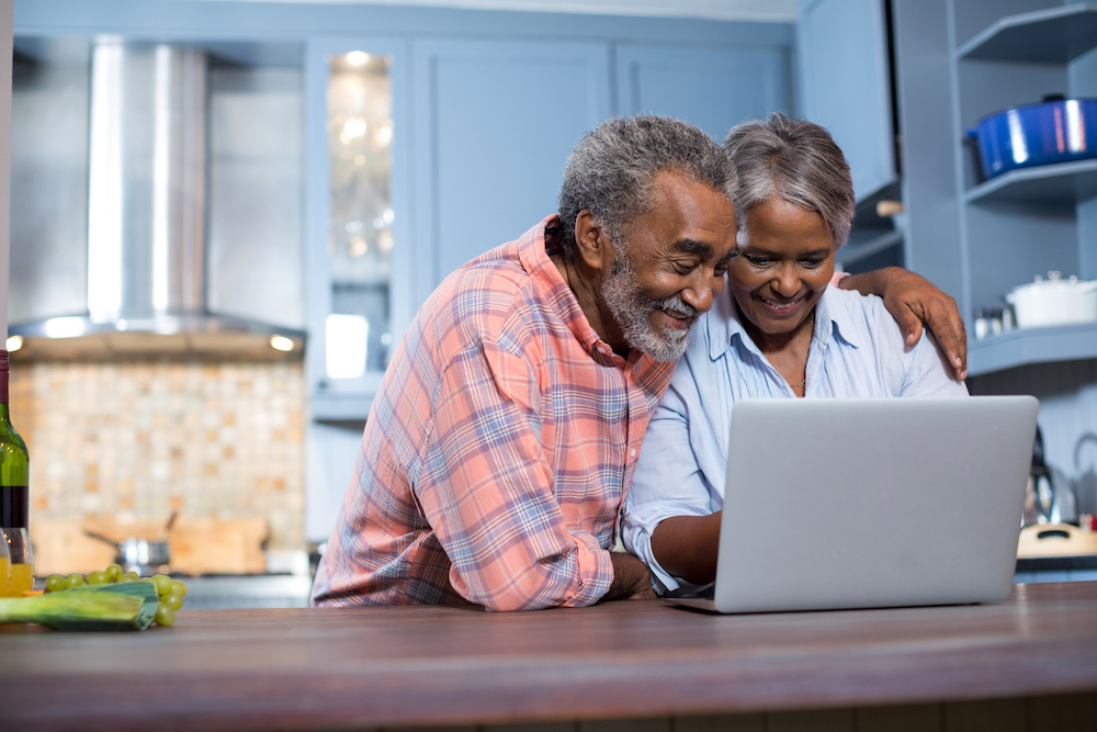 A senior couple using a computer to research senior living communities in their area