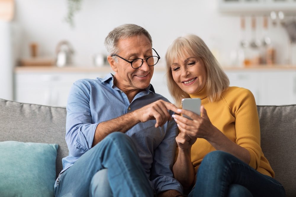 An older couple using social media on their smart phone