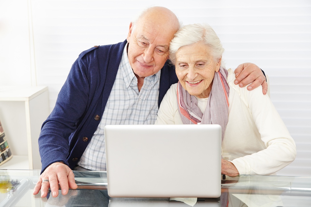A senior couple browsing for assisted living communities on their computer